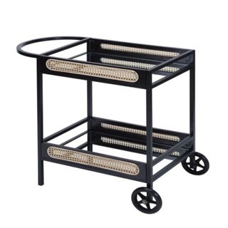 A bar cart with brown rattan inserts, two shelves, and wheels
