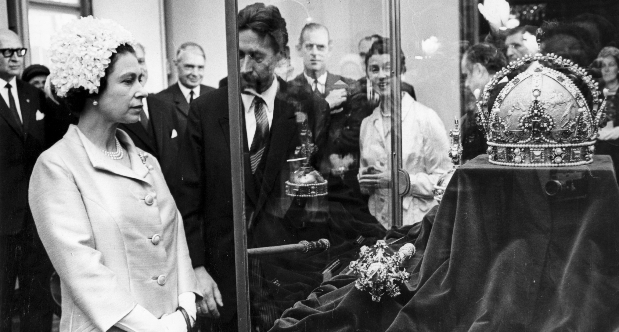 Queen Elizabeth looking at a crown inside a glass case
