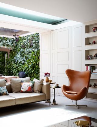 Modern living room with midcentury leather armchair and living wall