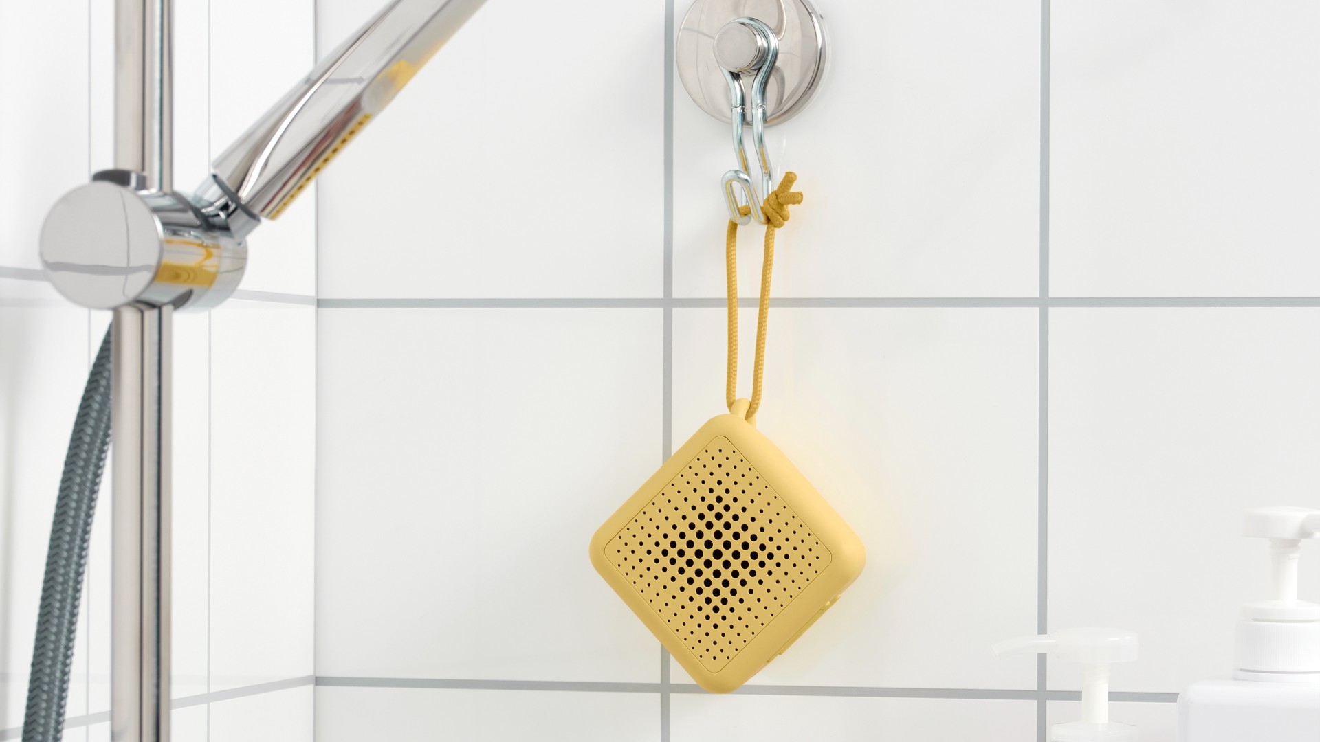 Altavoz Bluetooth IKEA Vappeby en amarillo, colgado en una ducha