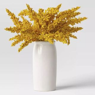 A goldenrod artificial yellow plant arrangement in a white ceramic tall vase is one of the best Target fall decor items.