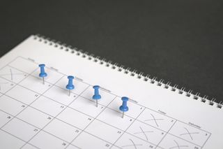 Four day working week represented by four blue pins in a calendar