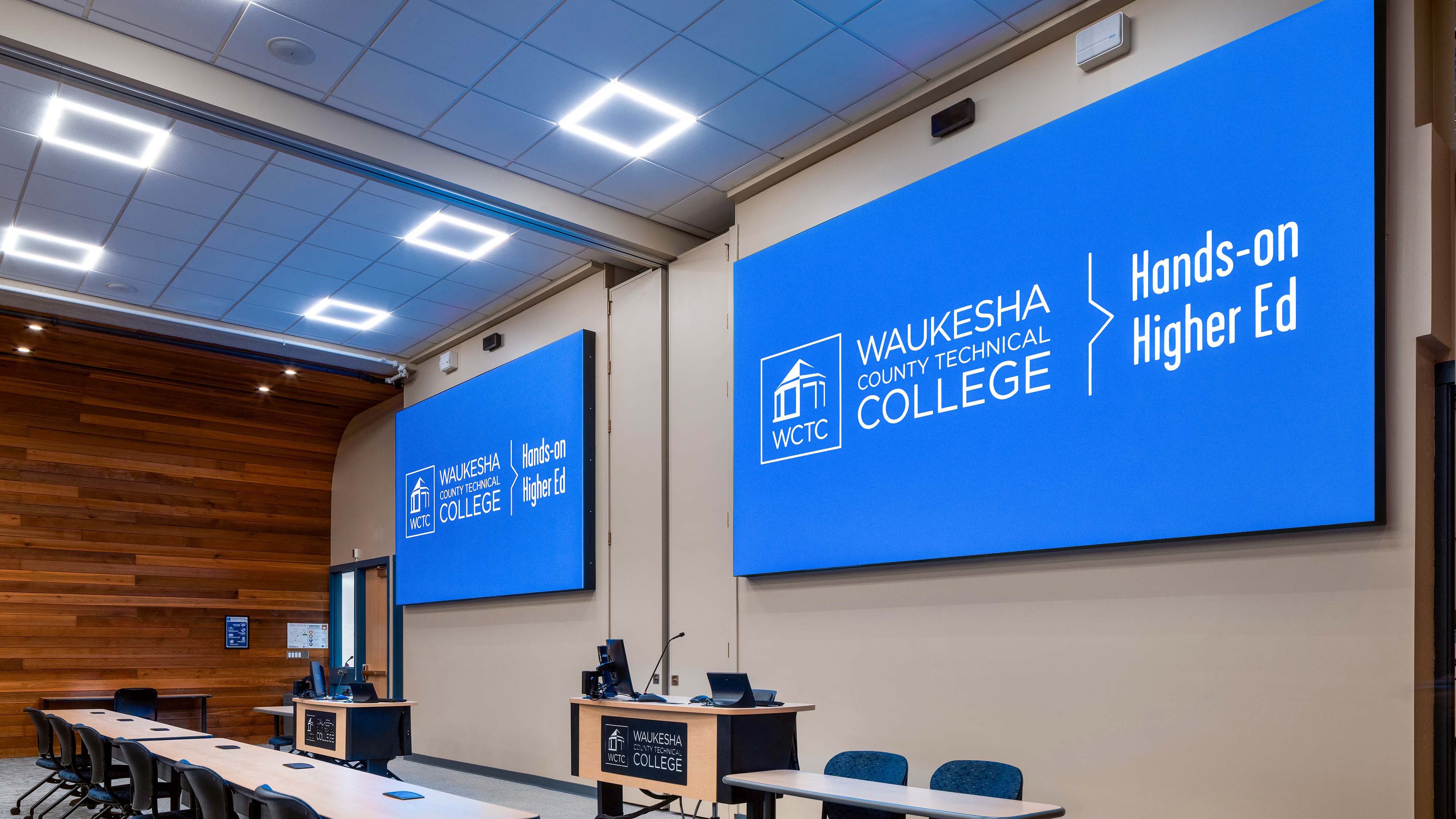 Two new LED displays showcase the college name in a classroom. 