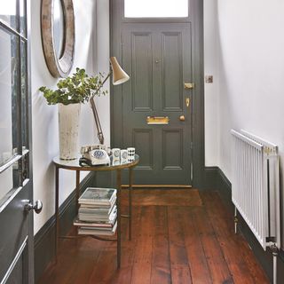 A white-painted hallway with contrasting dark grey skirting boards and front door