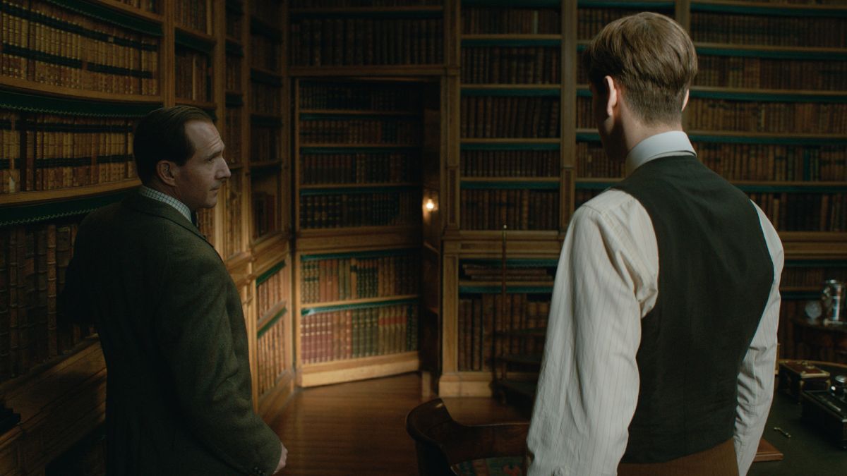 Ralph Fiennes and Harris Dickinson in front of a secret passage in The King&#039;s Man.