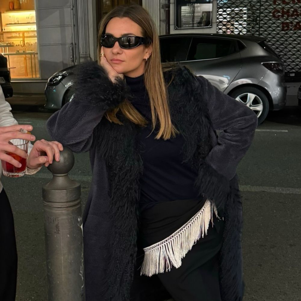 French influencer @annelauremais wears a fringed belt over a black dress.