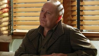 Red Reddington sitting at restaurant table in The Blacklist