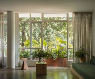 living room with white walls picture window and green sofa