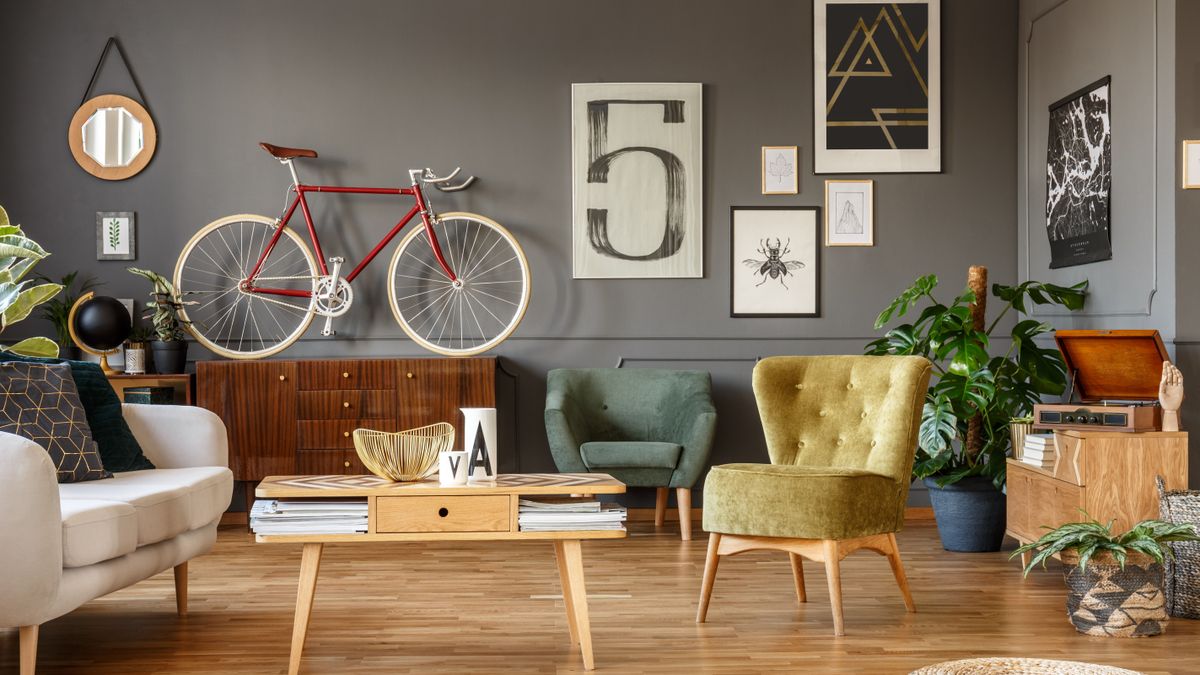 A cluttered living room with products on the surfaces and art on the walls