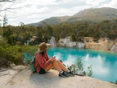 Woman on the cliff and looking at Little Blue lake in Tasmania