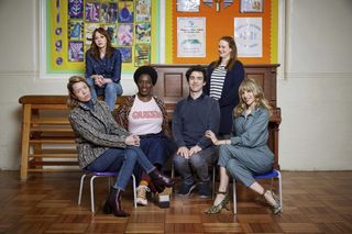 Motherland cast sitting in a school hall. 