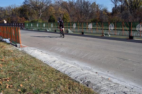 The transition from grass to asphalt at the course's final left turn onto the finishing straight.
