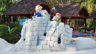 Elsa and Anna building snow fort at Blizzard Beach