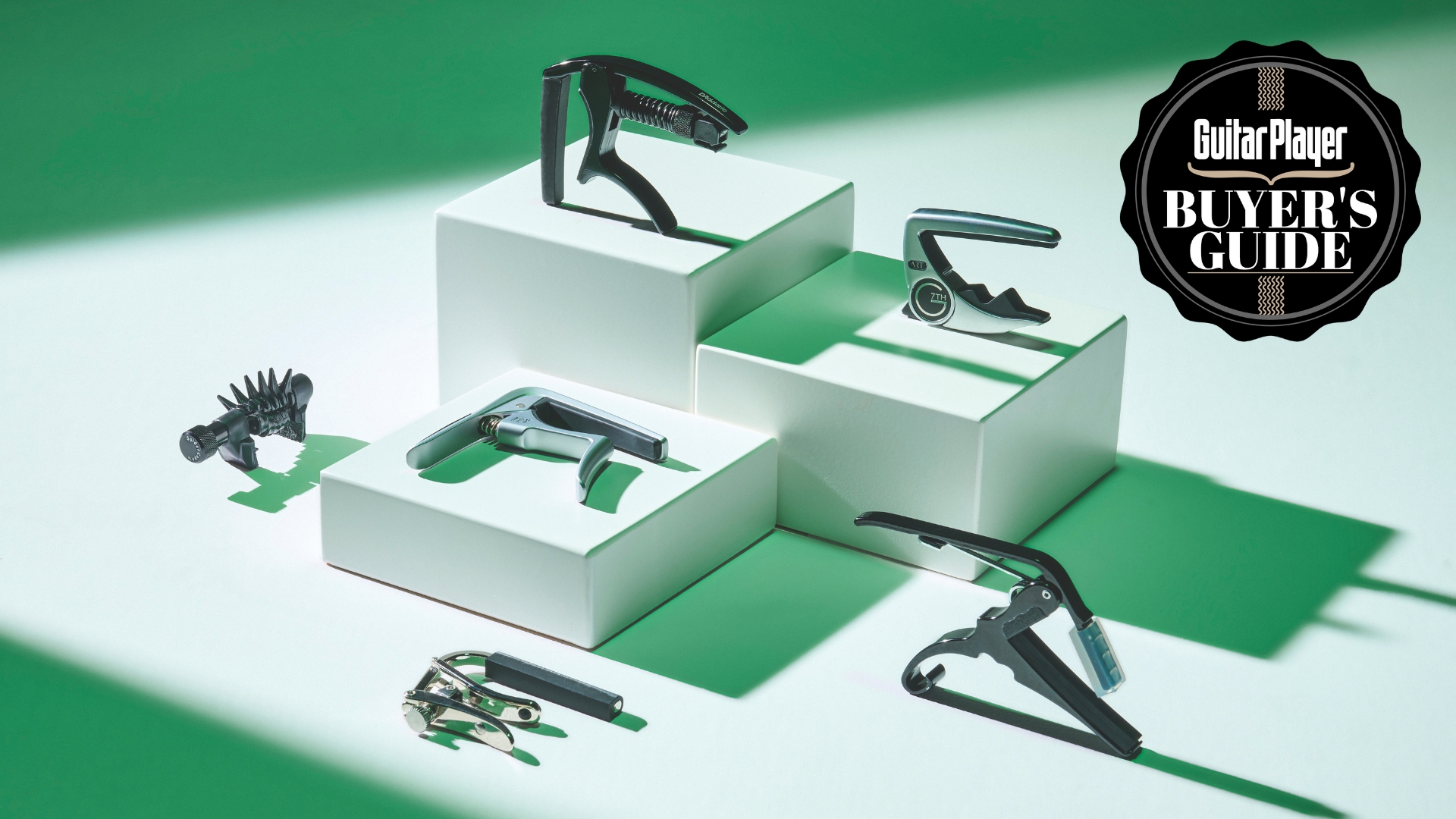 A selection of guitar capos at various heights with green lighting