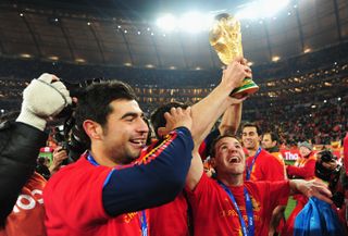 Raúl Albiol and Juan Mata celebrate with the World Cup trophy after Spain's win over the Netherlands in the final in July 2010.