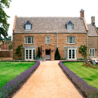 farmhouse with sloping roof tops white windows and door