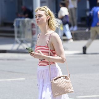 Elle Fanning wearing a white maxi skirt and striped tank top in New York