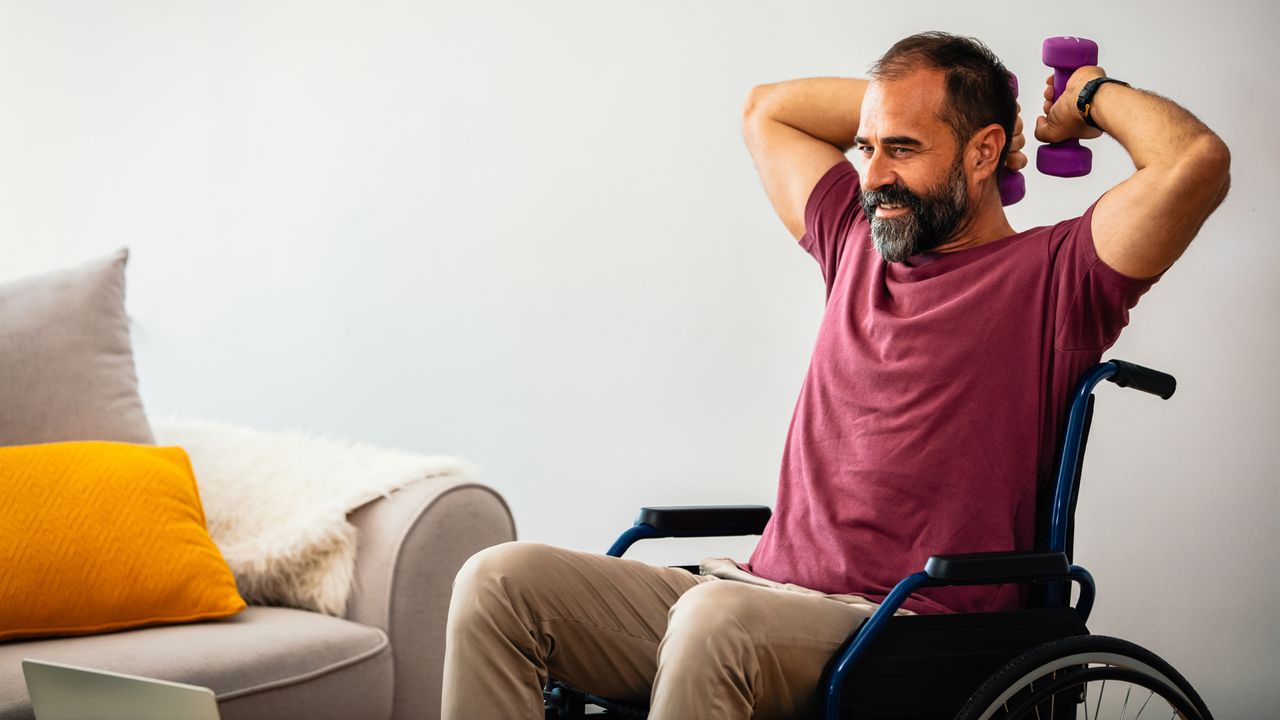 Man sitting in a wheelchair exercising with dumbbells