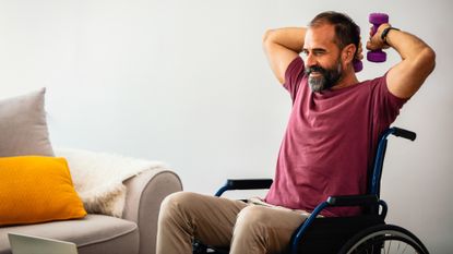 Man sitting in a wheelchair exercising with dumbbells