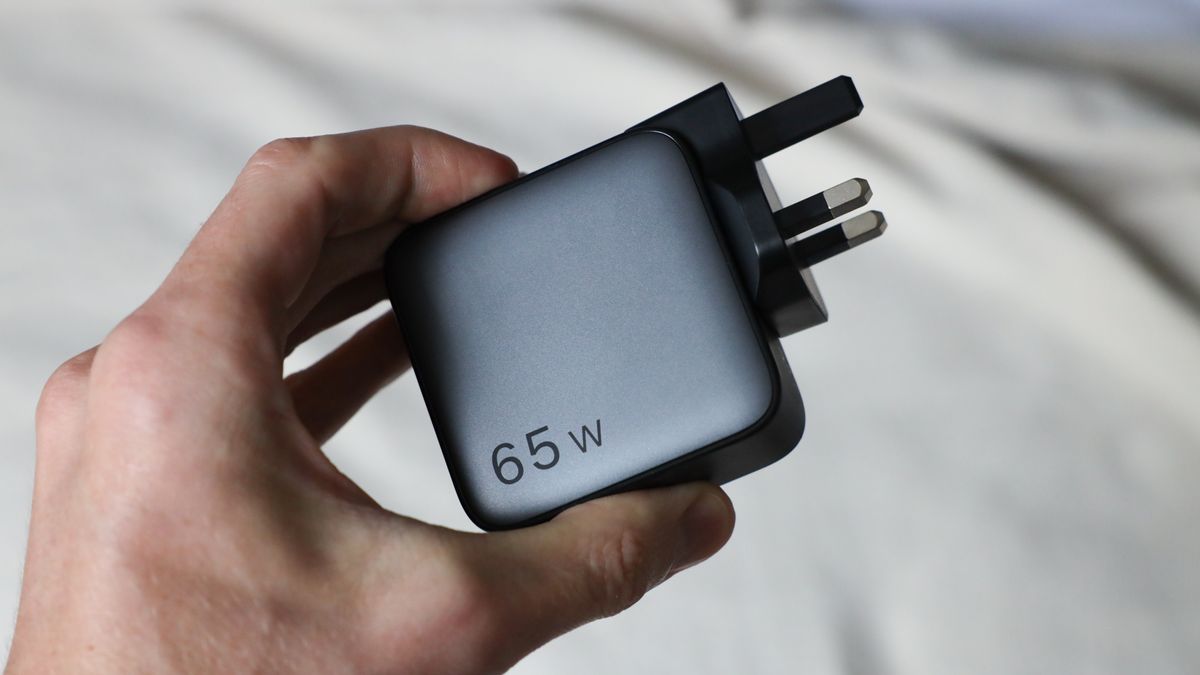 Ugreen Nexode 65W charger with UK plug held in a hand