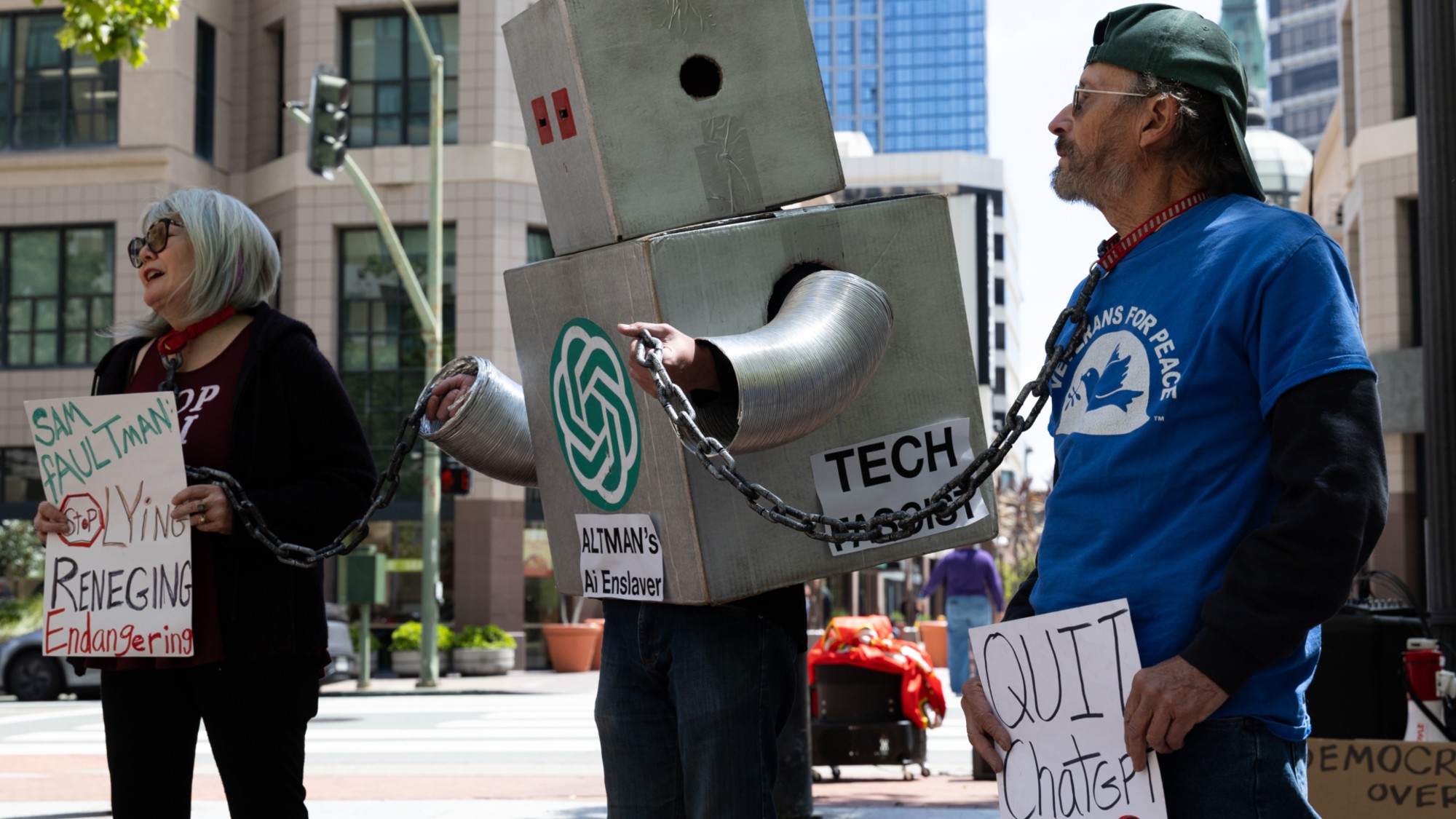 OAKLAND, CALIFORNIA - APRIL 27: Demonstrators protest against AI outside the courthouse at the Ronald V. Dellums Federal Building as jury selection begins in the lawsuit between Elon Musk and OpenAI on April 27, 2026 in Oakland, California. Elon Musk invested in OpenAI early on believing it would be a non-profit, but is now suing OpenAI and its CEO Sam Altman for allegedly deceiving him by developing OpenAI into a for-profit company. (Photo by Benjamin Fanjoy/Getty Images)