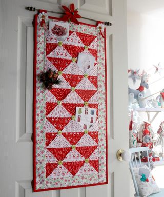 A red and white quilted Christmas card holder with cards inside pockets