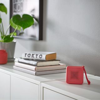 IKEA VAPPEBY speaker in red on a white cabinet with a plant and books next to it