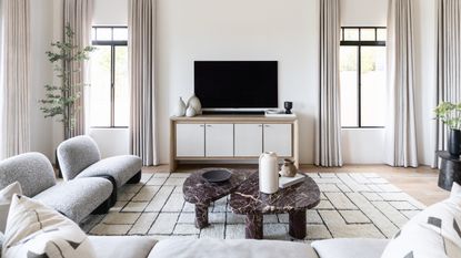 A neutral living room with neutral furniture and a large Berber rug