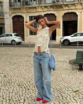 Girl wearing lace top, low-rise jeans, and red shoes in Lisbon