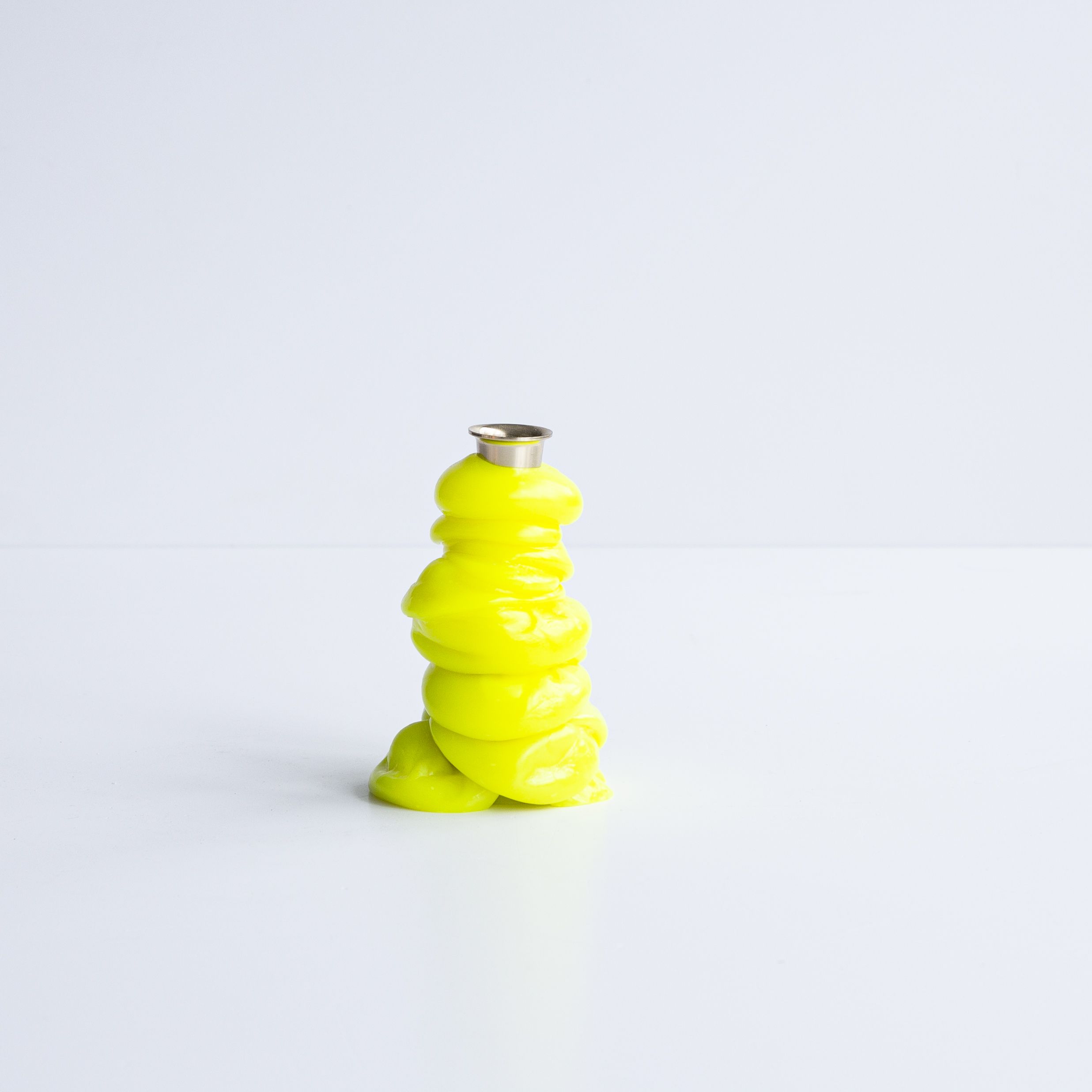 A series of squishy home objects designed from melted plastic and chrome or brass detailing, including a mirror, candelabra, and a kitchen towel rack.