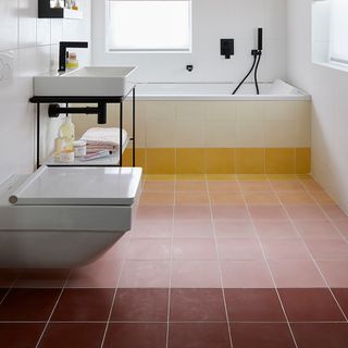 white bathroom with sunset ombre bath panel and floor tiles