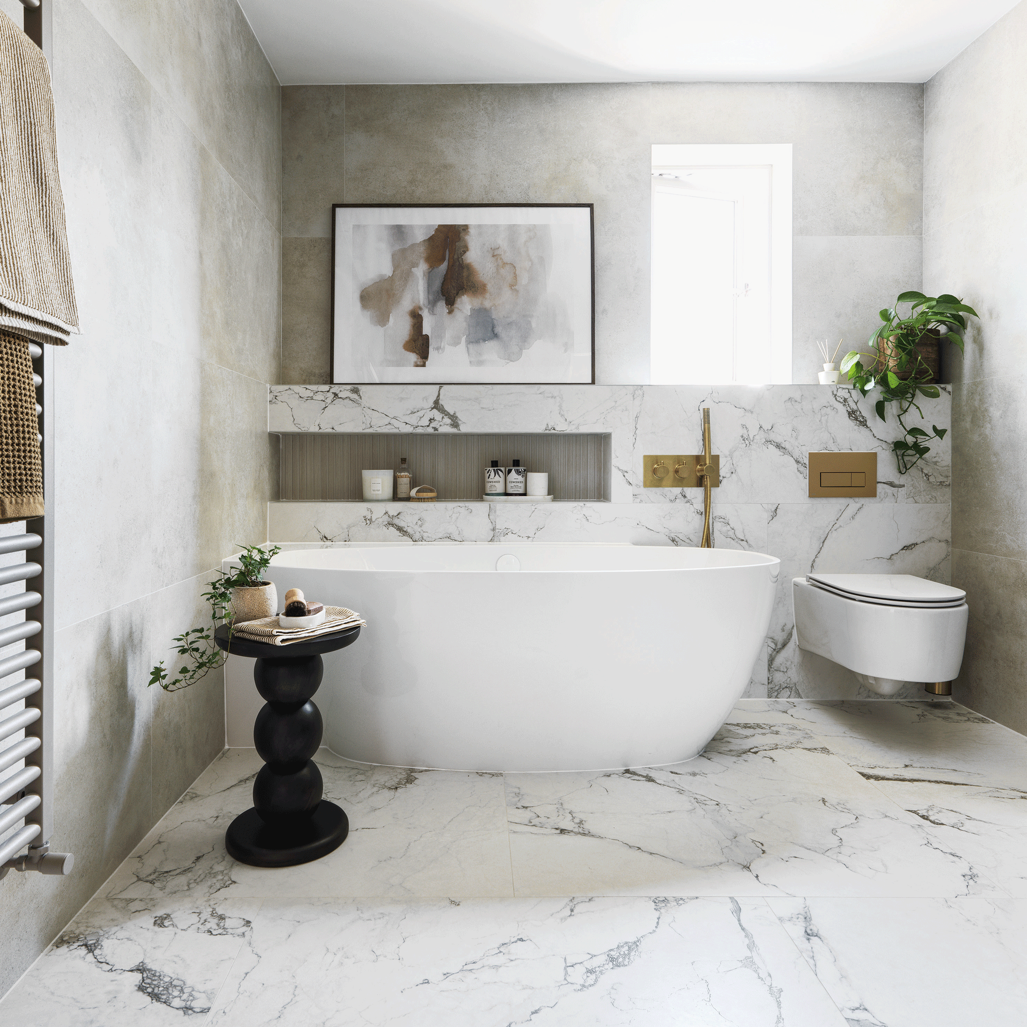 monochrome bathroom with marble walls and floor a large bath tun and wall hung loo