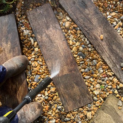 Pressure washer testing on patio, wood and a car