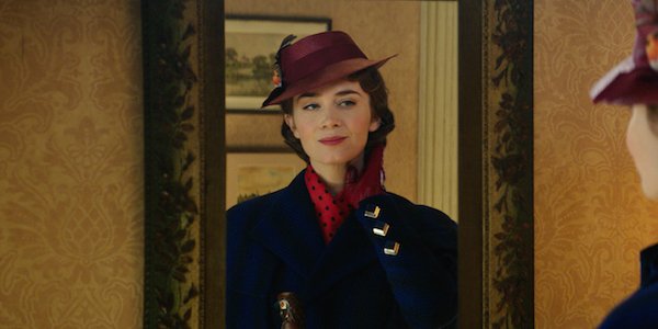 Emily Blunt as Mary Poppins looking at herself in a mirror and smirking in Mary Poppins Returns