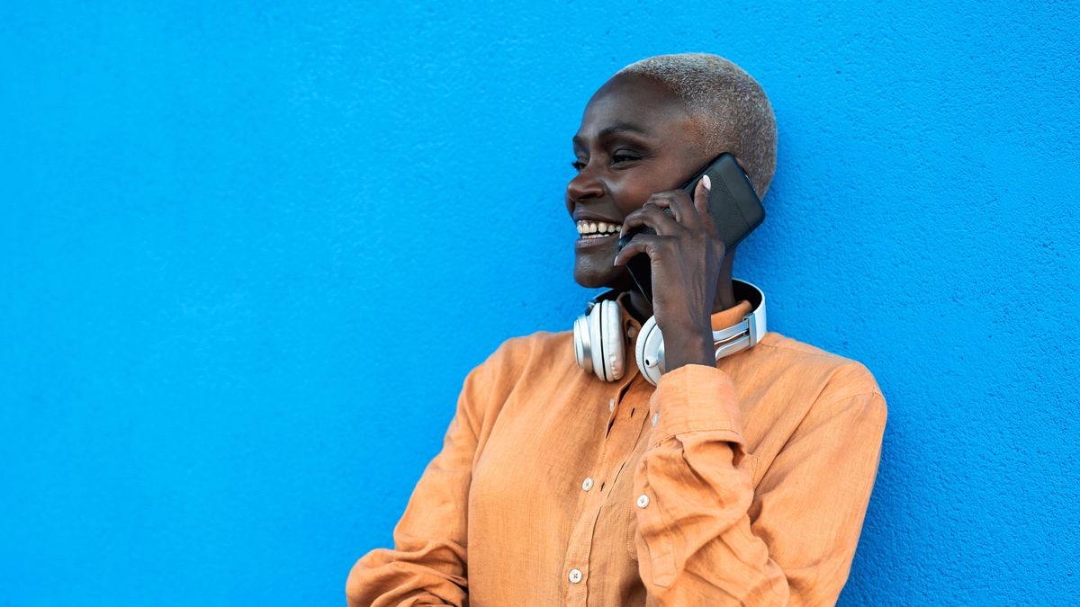 Woman on phone call wearing headphones around neck