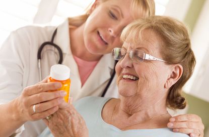 Female Doctor or Nurse Explaining Prescription to Senior Woman