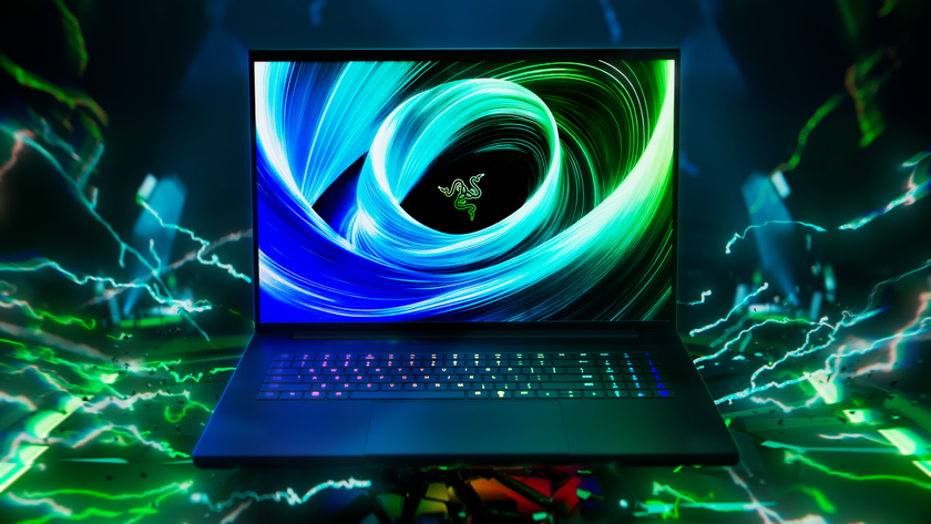 A front-facing shot of the Razer Blade 18 (2025) gaming laptop open on a black background with green sparks.