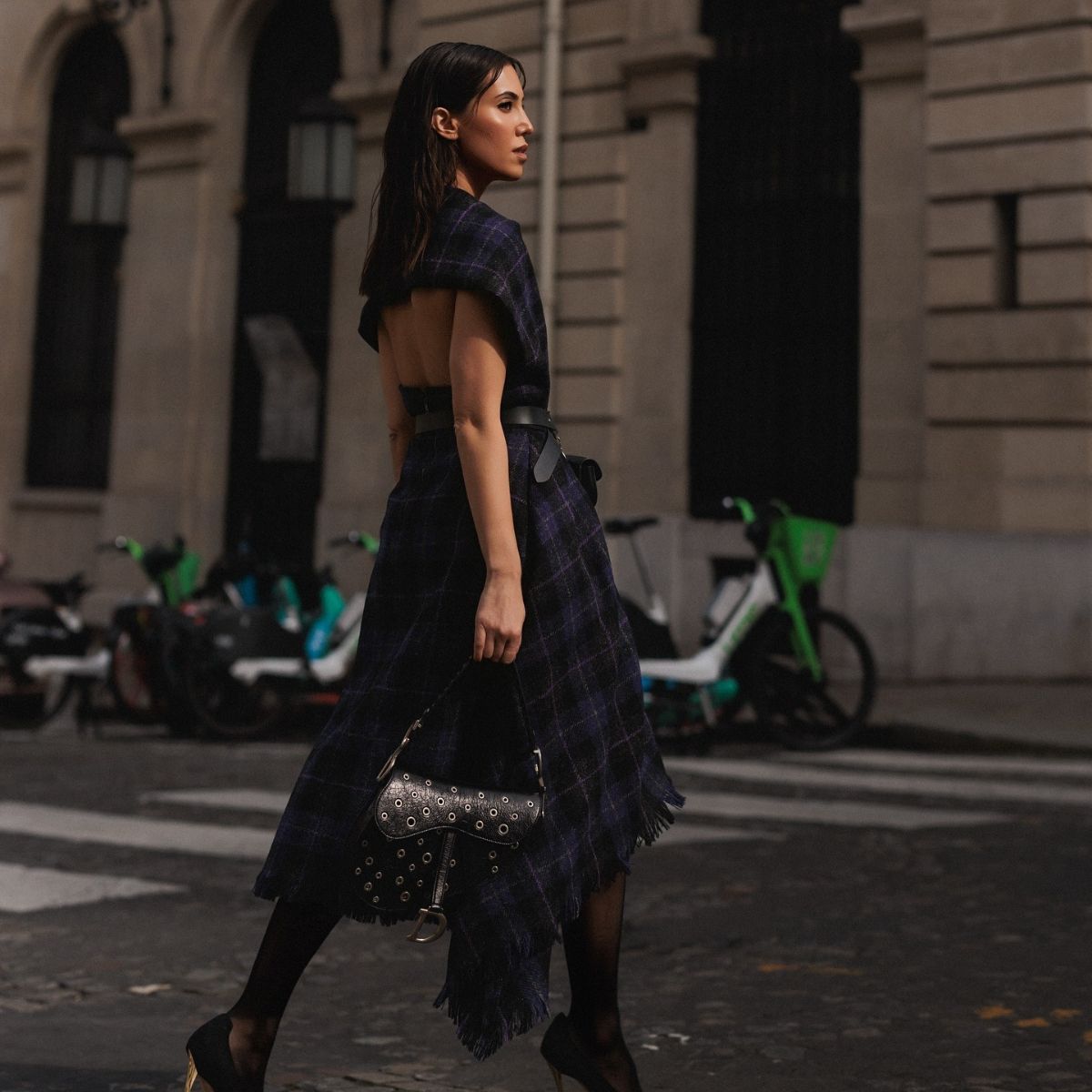 A woman in a plaid dress crossing the street in New York.