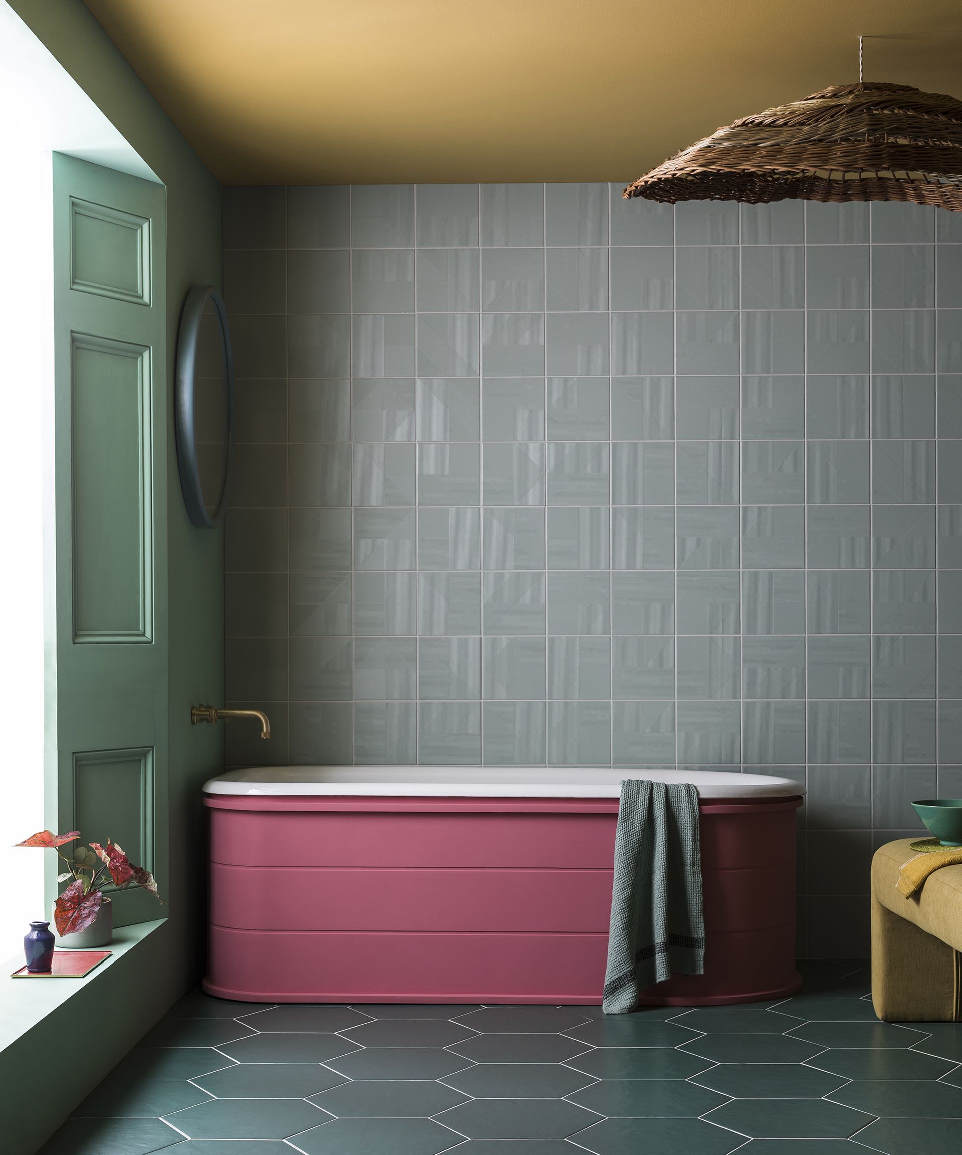 An example of bathroom color ideas showing a colorful bathroom with a pink bath and gray walls