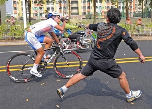 Park Sung-baek (Korea) grabs a bottle during the road race.