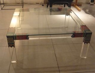 Lucite table with traditional designs in the corners