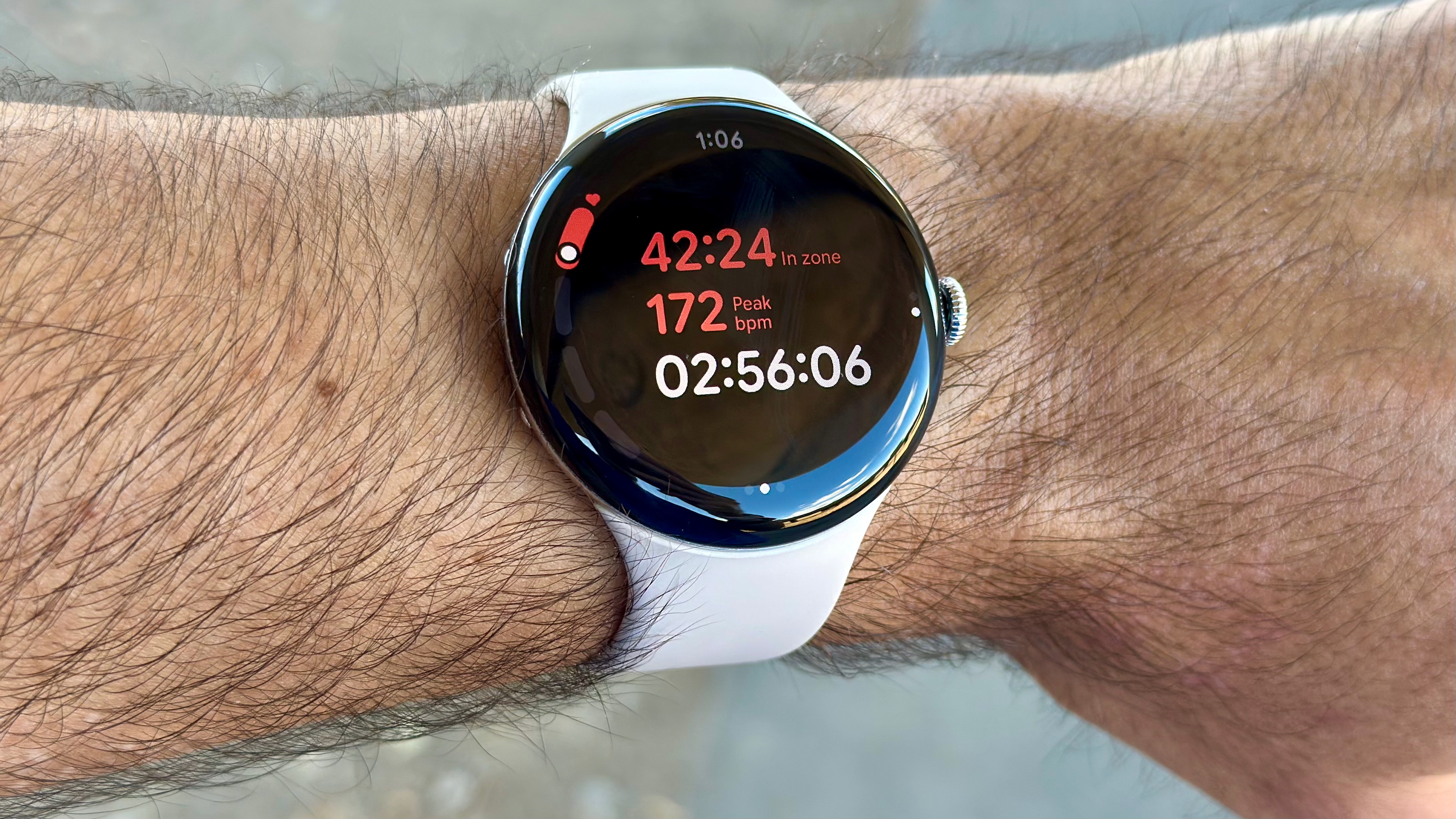 Close-up of the Google Pixel Watch 4 showing the HR zone run view, with a "time in zone" stat in red, with a "peak" HR of 172 below it, then the current run time in white.