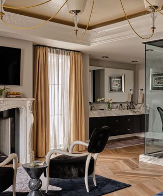 A bathroom with a seating area and large glass shower