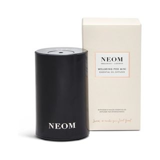 Neom Wellbeing Pod Mini in black beside box