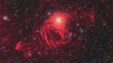 A shinning star inside the red, gaseous nebula.