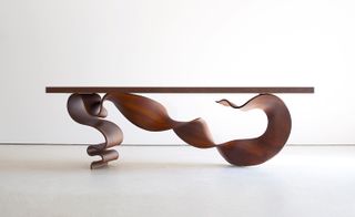Dark wooden coffee table with curvy abstract base