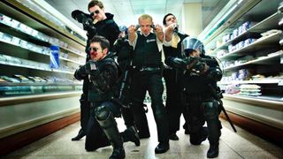 Simon Pegg as Nicholas Angel and Nick Frost as Police Constable Danny Butterman, along with the rest of the gang holding guns while in a super market during the comedy movie Hot Fuzz.