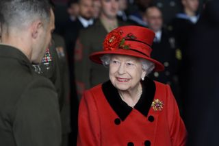 Queen Elizabeth II talks to military personnel during a visit to HMS Queen Elizabeth at HM Naval Base ahead of the ship's maiden deployment on May 22, 2021 in Portsmouth, England