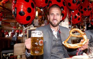 Harry Kane holding a beer and a pretzel at Oktoberfest