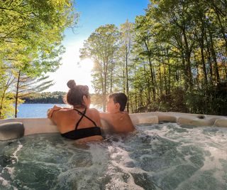 woman and child in hot tub overlooking a lake